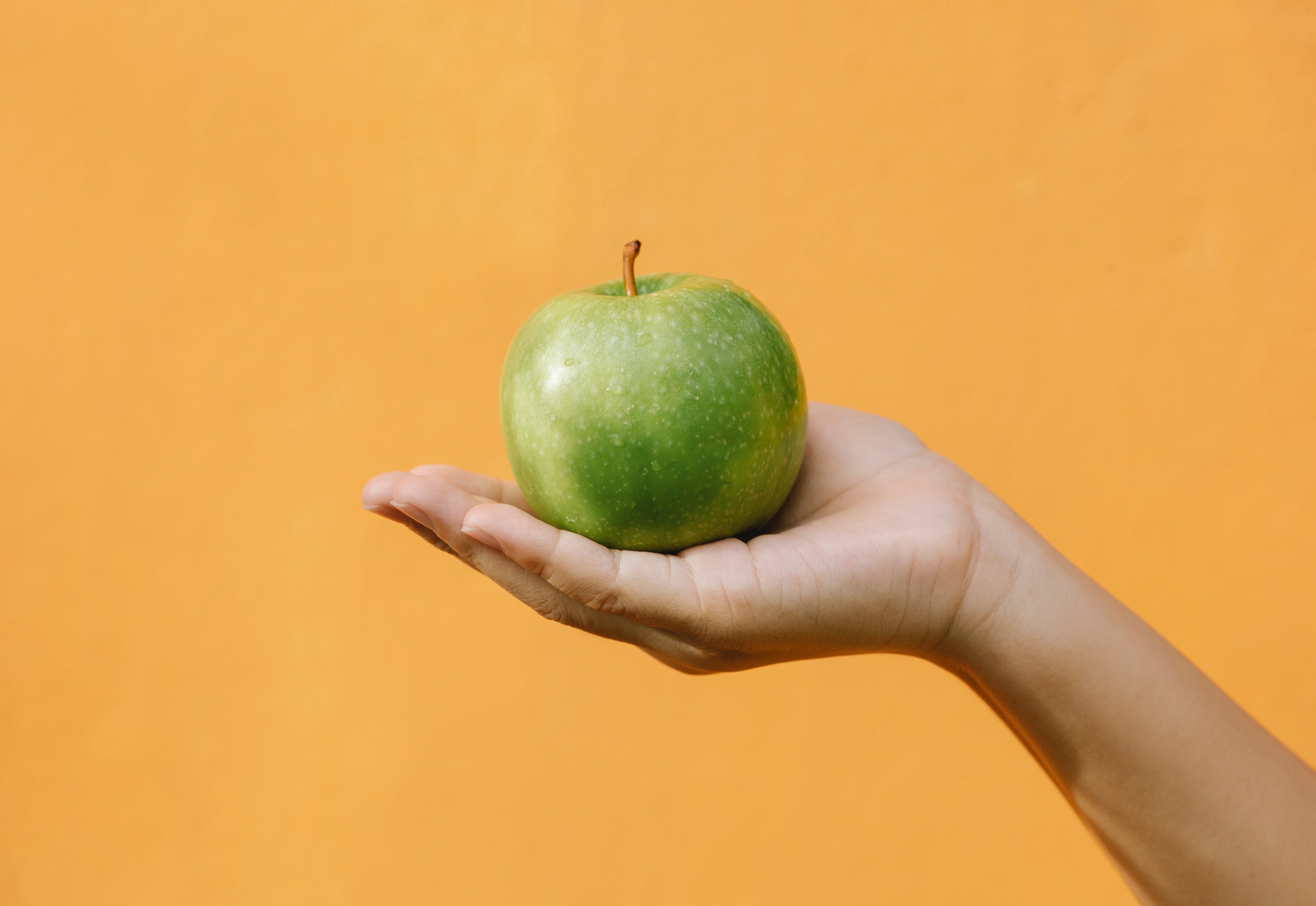 Apple being held in a hand- healthy eating for weight loss
